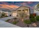Exterior of a home featuring a two-car garage, manicured landscaping, and stone accents at 2324 E Saguaro Park Ln, Phoenix, AZ 85024