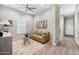 Cozy sitting room with neutral paint, wood floors, window and comfortable couch at 2324 E Saguaro Park Ln, Phoenix, AZ 85024