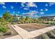 Community playground features a covered jungle gym, slide, swing set, and lush landscaping under a blue sky at 2324 E Saguaro Park Ln, Phoenix, AZ 85024