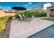 Relaxing poolside featuring comfortable lounge chairs with an umbrella, surrounded by lush greenery, and beautiful stone tile at 2324 E Saguaro Park Ln, Phoenix, AZ 85024