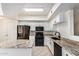 Bright kitchen features granite countertops, black appliances, an island, and white cabinetry at 2401 E Rio Salado Pkwy # 1048, Tempe, AZ 85288