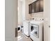 Well-lit laundry room features a modern washer and dryer, plus dark wood cabinetry for added storage at 2412 W Gloria Ln, Phoenix, AZ 85085