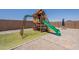 A roomy backyard with a play structure on turf and a paved patio area at 29481 W Mitchell Ave, Buckeye, AZ 85396