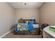 Carpeted bedroom with a ceiling fan, a bed with built-in shelves, a white storage unit, and neutral grey walls at 29481 W Mitchell Ave, Buckeye, AZ 85396