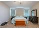 Bedroom with a ceiling fan, carpet floors, a queen bed, nightstands, dressers, a cedar chest, and light blue curtains at 29481 W Mitchell Ave, Buckeye, AZ 85396
