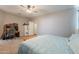 Bedroom featuring a ceiling fan, a desk area, carpet floors, a queen bed, and neutral grey walls at 29481 W Mitchell Ave, Buckeye, AZ 85396