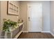 Entryway with wood-look flooring, a white front door, and decorated with a console table and plants at 29481 W Mitchell Ave, Buckeye, AZ 85396