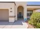 Close-up of a home's entrance featuring an arched doorway, a welcome mat, and desert landscaping at 29481 W Mitchell Ave, Buckeye, AZ 85396
