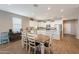 Open-concept kitchen featuring stainless steel appliances, white cabinetry, a breakfast bar and a dining table at 29481 W Mitchell Ave, Buckeye, AZ 85396