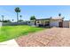 Expansive backyard featuring a manicured lawn, covered patio with seating, and a charming walkway leading to a gated entrance at 3050 E Cholla E St, Phoenix, AZ 85028