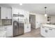 Contemporary kitchen with white cabinets, stainless steel refrigerator, and wood-look flooring at 3050 E Cholla E St, Phoenix, AZ 85028