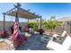 Inviting backyard featuring a cozy lounge area with fire pit, lush greenery, and a charming pergola at 36076 W Santa Barbara Ave, Maricopa, AZ 85138
