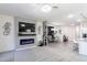 Spacious living room with a cozy fireplace, TV, and an open view into the dining area at 36076 W Santa Barbara Ave, Maricopa, AZ 85138
