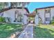 Inviting townhome with a lush green lawn, mature trees, and a charming pergola-covered entrance at 3637 E Monterosa St # 8, Phoenix, AZ 85018