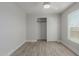 Bright bedroom featuring wood-look flooring, a ceiling fan, closet, and a window at 3952 E Baywood Ave, Mesa, AZ 85206