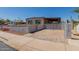 Charming single-Gathering home featuring a gated driveway, covered parking, and a well-maintained front yard at 3952 E Baywood Ave, Mesa, AZ 85206