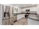 Modern kitchen with stainless steel appliances and sleek white cabinets and grey countertops at 3952 E Baywood Ave, Mesa, AZ 85206