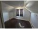 Attic bedroom featuring a window, sloping walls, and weathered floors at 4112 S Grandview Ave, Tempe, AZ 85282