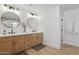 Bathroom with double sinks, modern mirrors, and wood cabinets at 4842 E Surrey Ave, Scottsdale, AZ 85254