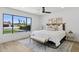 Bright bedroom with white bedding, a fan, and a large window looking out to the yard at 4842 E Surrey Ave, Scottsdale, AZ 85254