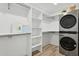 Walk-in closet with washer and dryer and built-in shelving for ample storage at 4842 E Surrey Ave, Scottsdale, AZ 85254