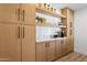 Pantry featuring natural wood cabinets, white subway tile backsplash, and modern design elements at 4842 E Surrey Ave, Scottsdale, AZ 85254