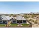 Aerial view of the backyard with artificial turf and a covered patio, mountains in the background at 520 E Ashurst Dr, Phoenix, AZ 85048