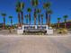 Community entrance sign surrounded by lush palm trees and beautiful landscaping at 520 E Ashurst Dr, Phoenix, AZ 85048