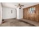 Living room with wood accent wall, carpet flooring, ceiling fan and an entry door on the left at 539 E Pebble Beach Dr, Tempe, AZ 85282