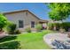 Spacious backyard showcasing a lush green lawn, a circular patio with a fire pit, and mature trees at 549 E Quentin Ln, San Tan Valley, AZ 85140