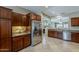 Spacious kitchen showcasing stainless steel refrigerator, tile flooring, and adjacent living area at 549 E Quentin Ln, San Tan Valley, AZ 85140