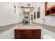 Well lit bathroom featuring a vanity with a sink, a mirror with Hollywood lights, and wooden cabinets at 6009 W Medlock Dr, Glendale, AZ 85301