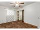 This bedroom features neutral walls, a ceiling fan, a window, and a closet with mirrored sliding doors at 6009 W Medlock Dr, Glendale, AZ 85301