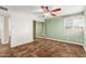 This bedroom features neutral walls, a ceiling fan, a window, and a closet with mirrored sliding doors at 6009 W Medlock Dr, Glendale, AZ 85301