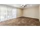 Bright living room featuring a ceiling fan, neutral walls, and large sliding glass doors to the outdoor space at 6009 W Medlock Dr, Glendale, AZ 85301