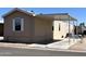 Tan mobile home with an attached carport and well maintained landscaping and desert environment at 625 W Mckellips Rd # 358, Mesa, AZ 85201
