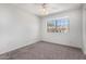 Empty bedroom featuring plush carpet, a bright ceiling fan, and a sunny window offering neighborhood views at 633 W Southern Ave # 1181, Tempe, AZ 85282
