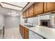 Open kitchen layout with a breakfast bar, tiled flooring, wood cabinets and an adjacent dining area with natural lighting at 633 W Southern Ave # 1181, Tempe, AZ 85282