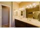 Bright bathroom featuring double sinks, vanity mirrors, and a doorway leading to another bathroom at 6605 N 93Rd Ave # 1035, Glendale, AZ 85305