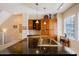 Open kitchen with a sink-equipped island featuring dark countertops, pendant lighting, and modern appliances at 6605 N 93Rd Ave # 1035, Glendale, AZ 85305