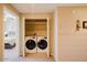 Convenient laundry room featuring a washer and dryer inside a closet with shelving for storage at 6605 N 93Rd Ave # 1035, Glendale, AZ 85305
