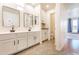 Bathroom featuring dual sinks, white cabinets, decorative mirrors, and modern fixtures at 706 E Washington St # 124, Phoenix, AZ 85034