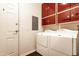 Efficient laundry room with bright red cabinets, white washer and dryer, and convenient access door at 706 E Washington St # 124, Phoenix, AZ 85034