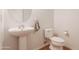 A well-lit powder room featuring a pedestal sink and a modern toilet at 706 E Washington St # 124, Phoenix, AZ 85034