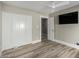 Bedroom features include a ceiling fan, mounted television, closet and wood-look flooring at 7731 E Rose Ln, Scottsdale, AZ 85250
