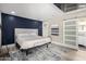 Bedroom with accent wall, plush bed, sliding door to the bathroom, and contemporary decor at 7731 E Rose Ln, Scottsdale, AZ 85250