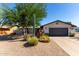 Inviting single-story home with low-maintenance desert landscaping and a dark gray two-car garage at 7731 E Rose Ln, Scottsdale, AZ 85250