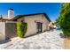 Exterior view of a home with a stone-paved patio and a glimpse of the refreshing pool at 7731 E Rose Ln, Scottsdale, AZ 85250