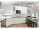 Bright kitchen with white cabinets, granite countertops, stainless steel appliances, and a breakfast bar at 7731 E Rose Ln, Scottsdale, AZ 85250