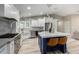 Modern kitchen with white cabinets, stainless steel appliances, and a blue island with bar stools at 7731 E Rose Ln, Scottsdale, AZ 85250